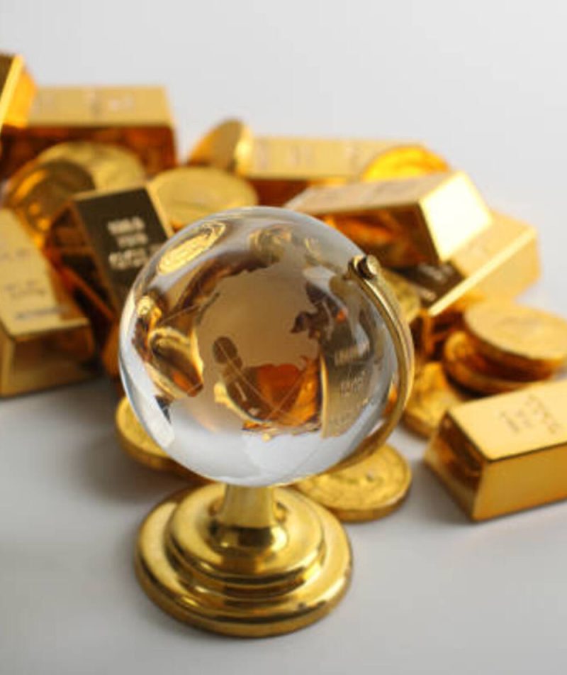 Coins and ingots with glass globe